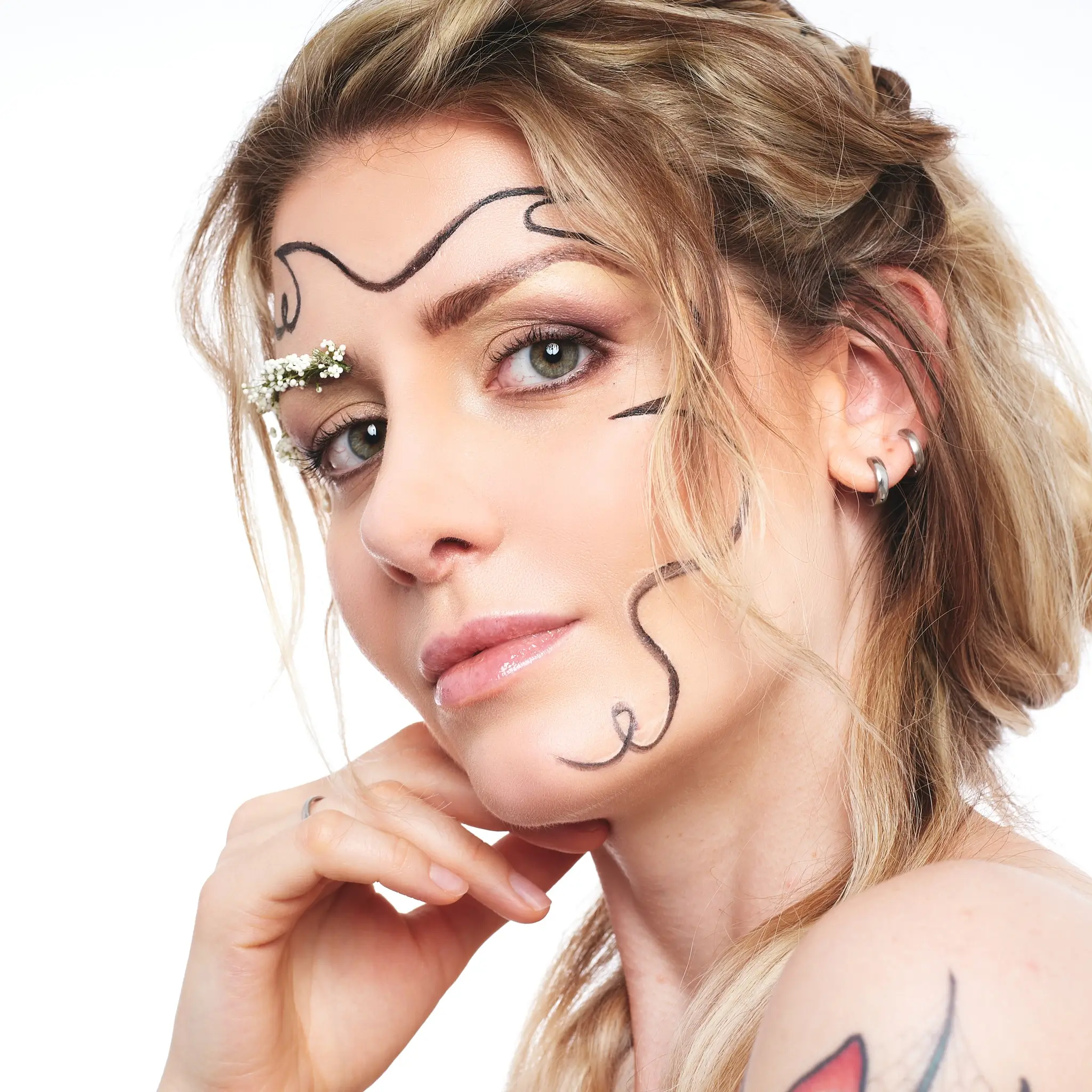 Beauty studio portrait of blonde model with creative makeup