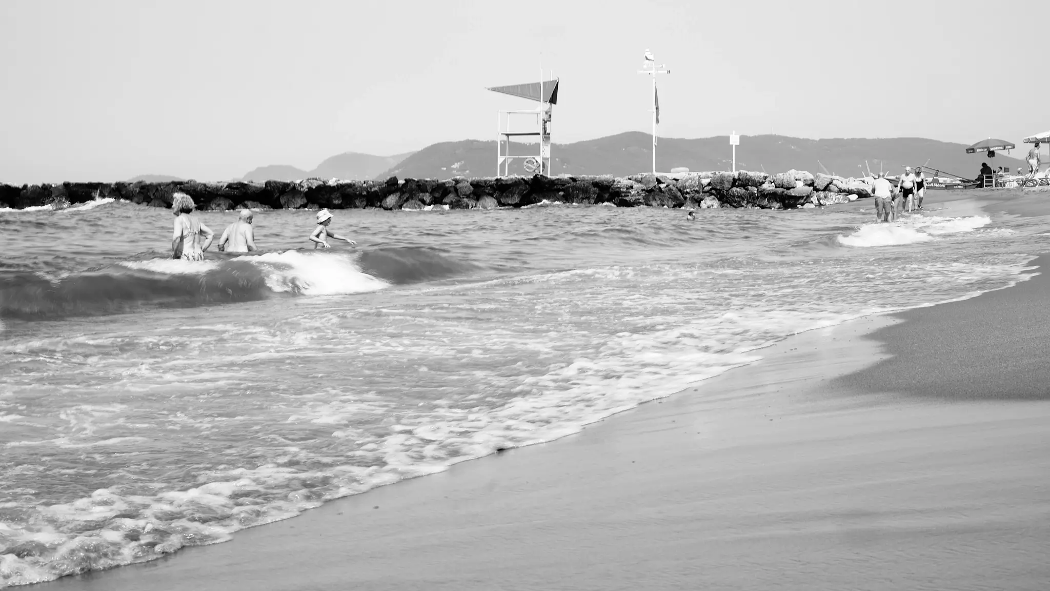 Black and white landscape photography of a beach with waves and rocks