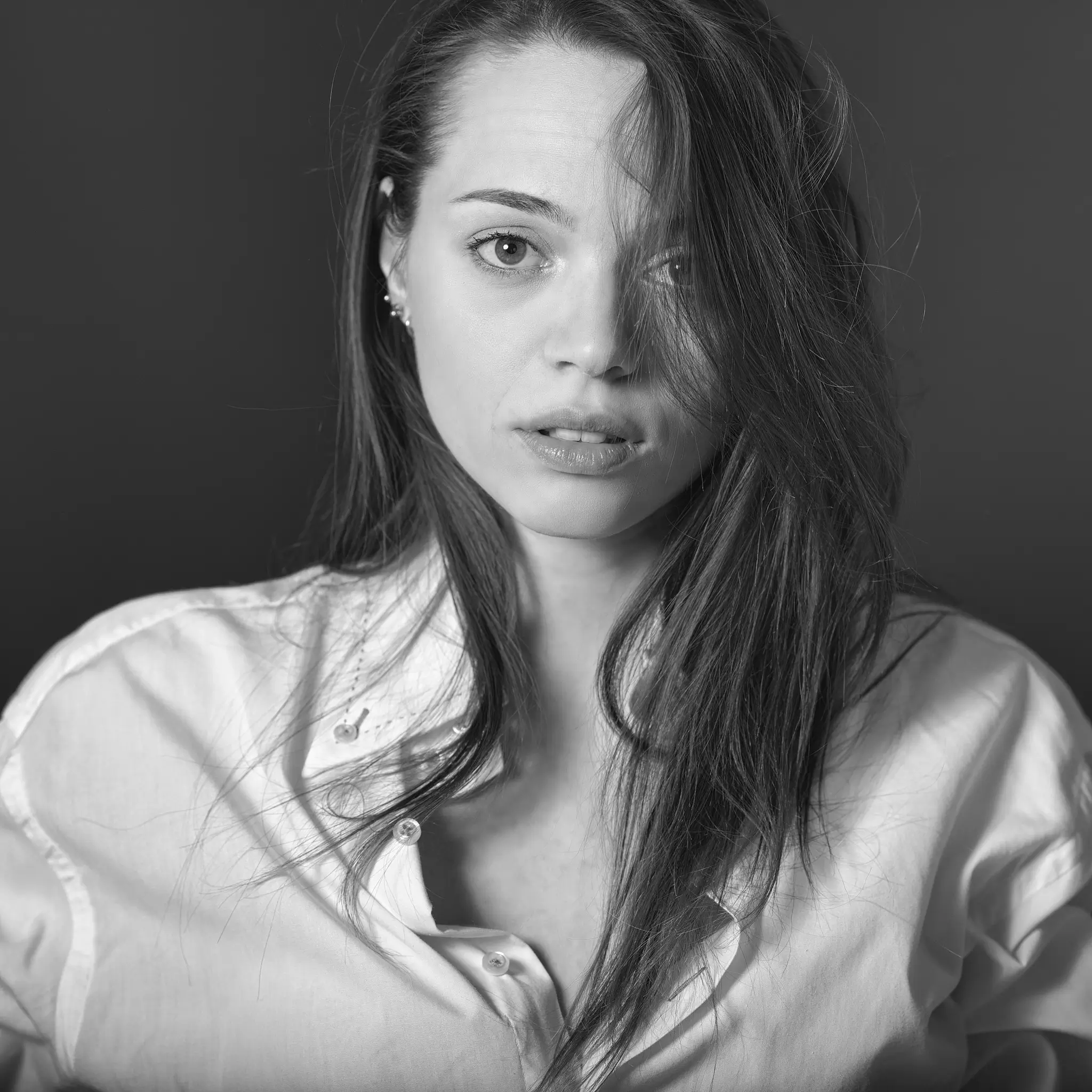 Black and white studio portrait of model with white shirt