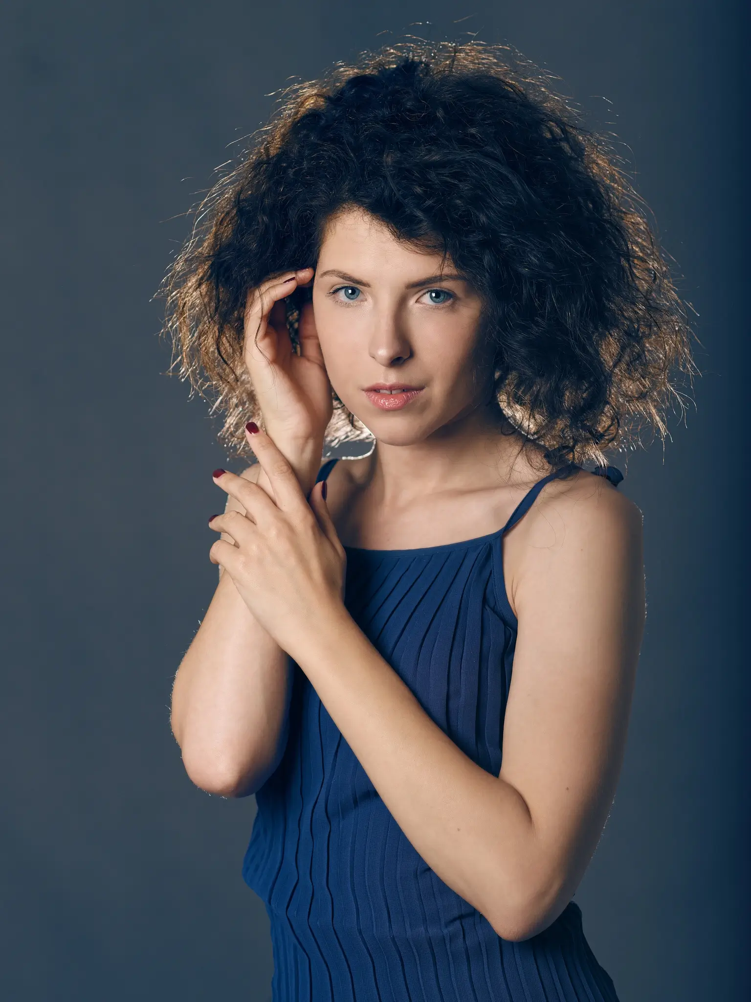Studio portrait of brunette model with blue dress on blue background