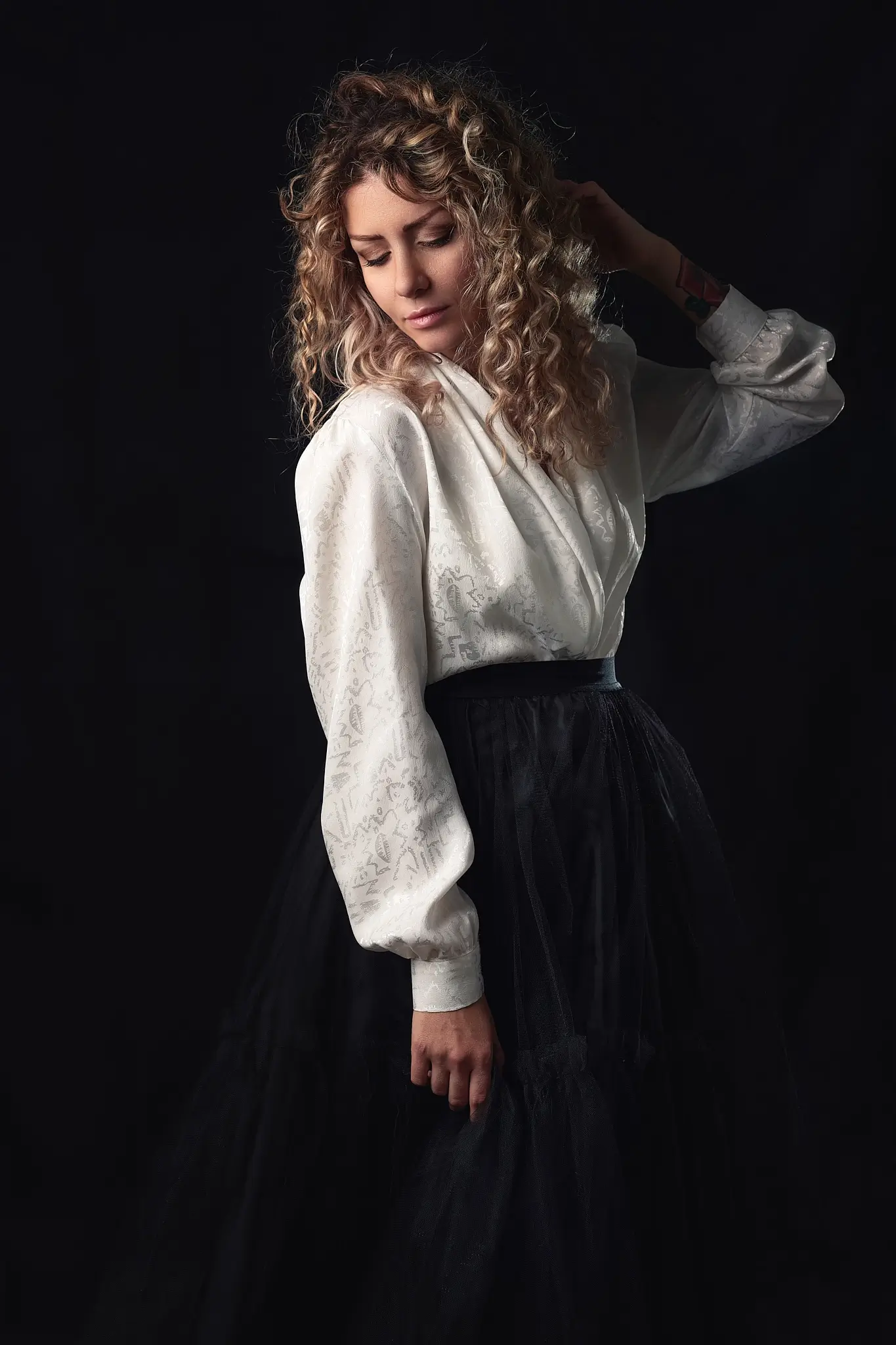 Studio portrait of blonde model on dark background