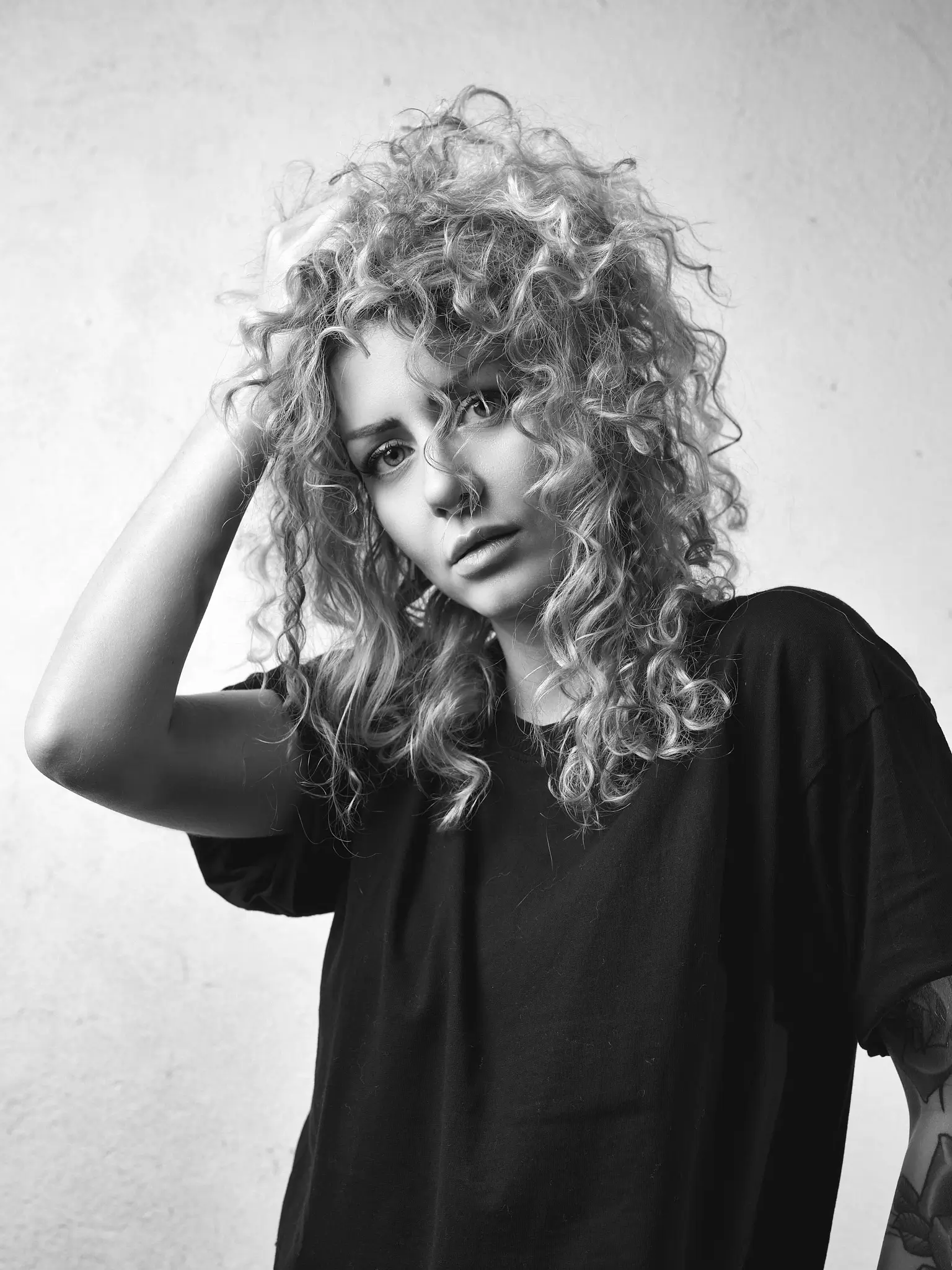 Black and white studio portrait of blonde model on white background