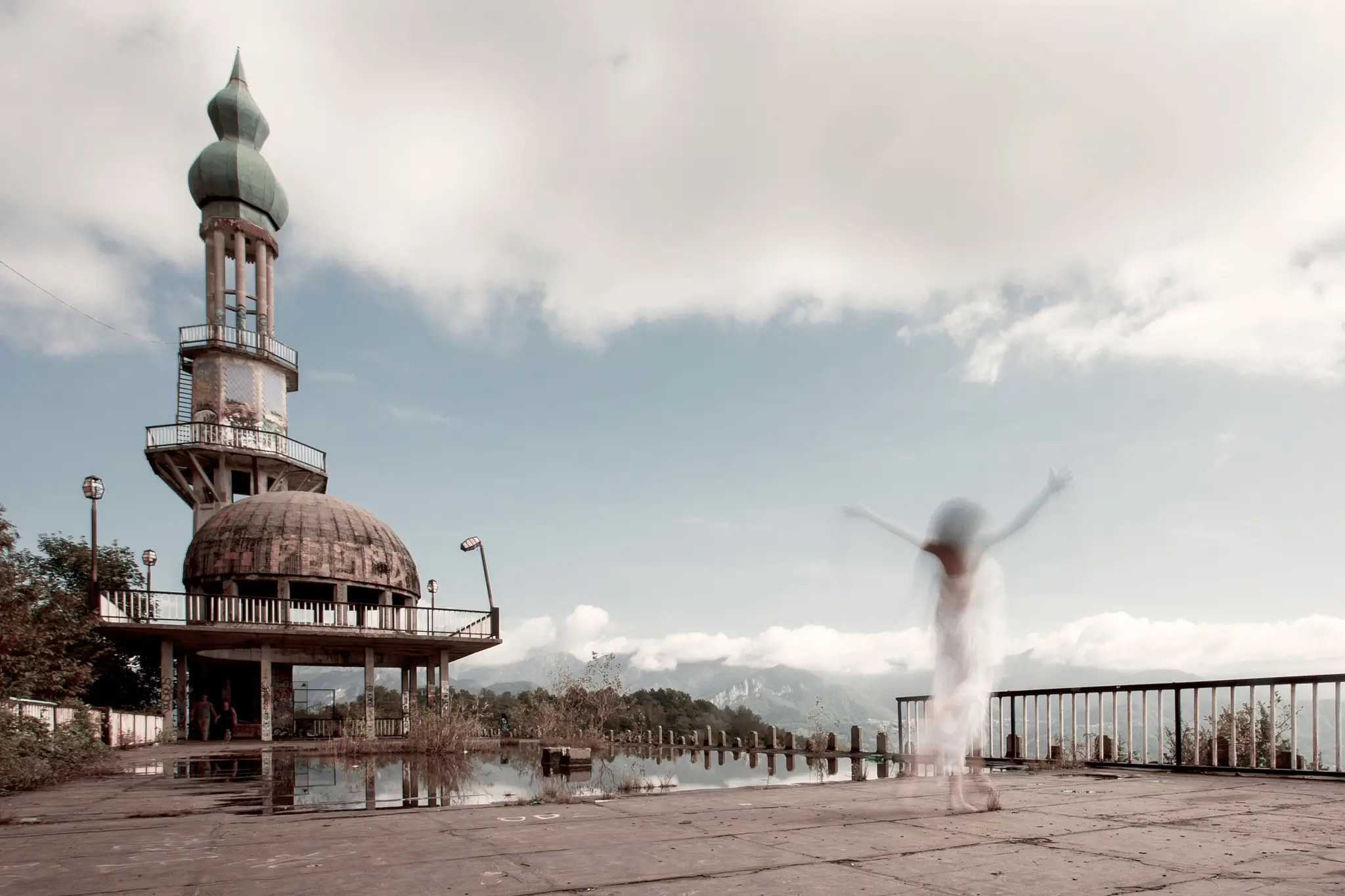 Outdoor long exposure portrait of model in white dress walking in an abandoned place
