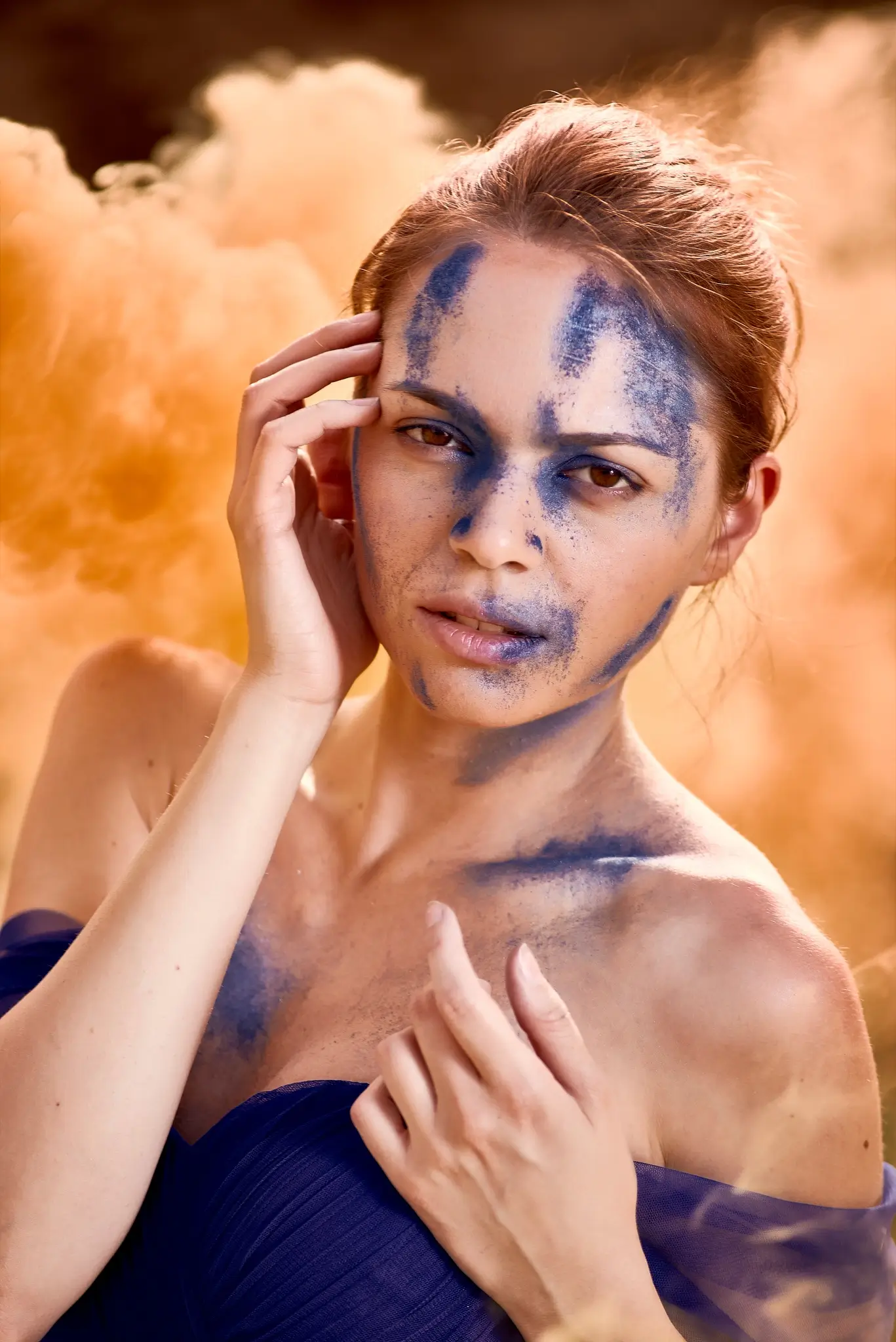 Portrait of model with blue dress and makeup and orange smoke
